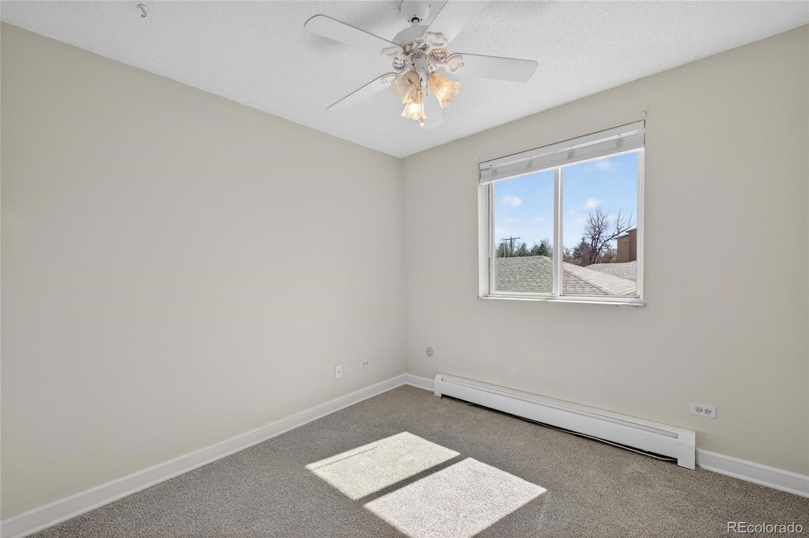 720 South Clinton Street, Unit B1 Denver, CO 80247 - Photo 12 of 19 an empty room with a window and a ceiling fan