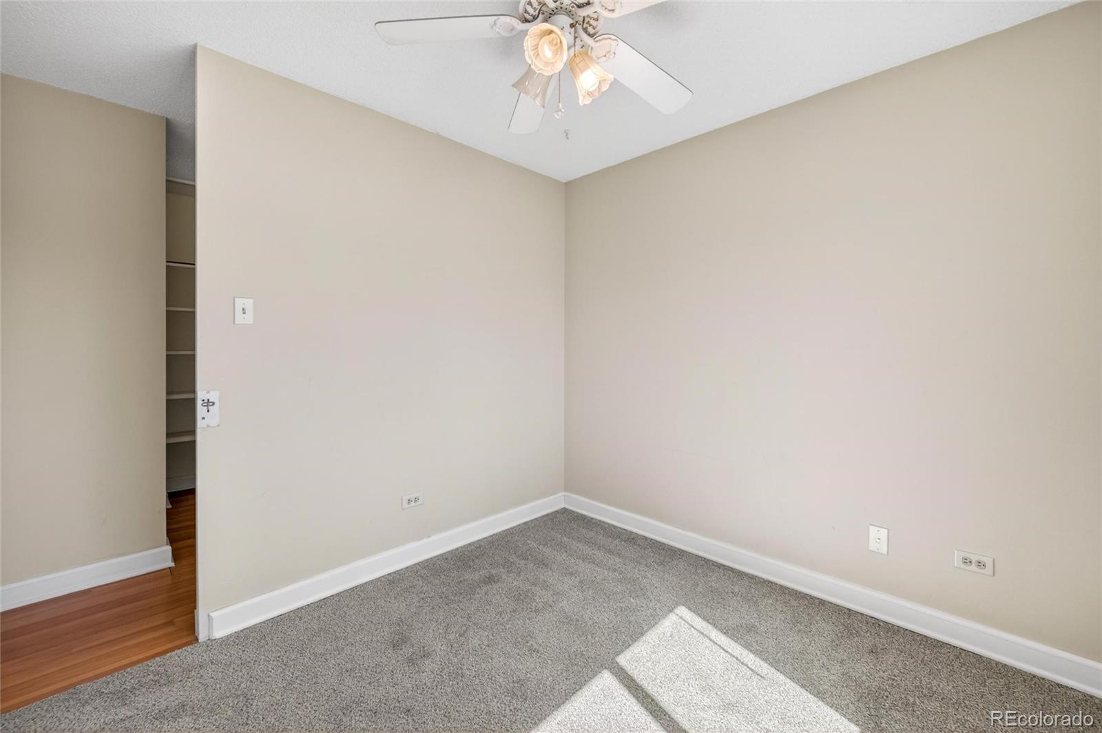 720 South Clinton Street, Unit B1 Denver, CO 80247 - Photo 14 of 19 an empty room with a chandelier fan and wooden floor