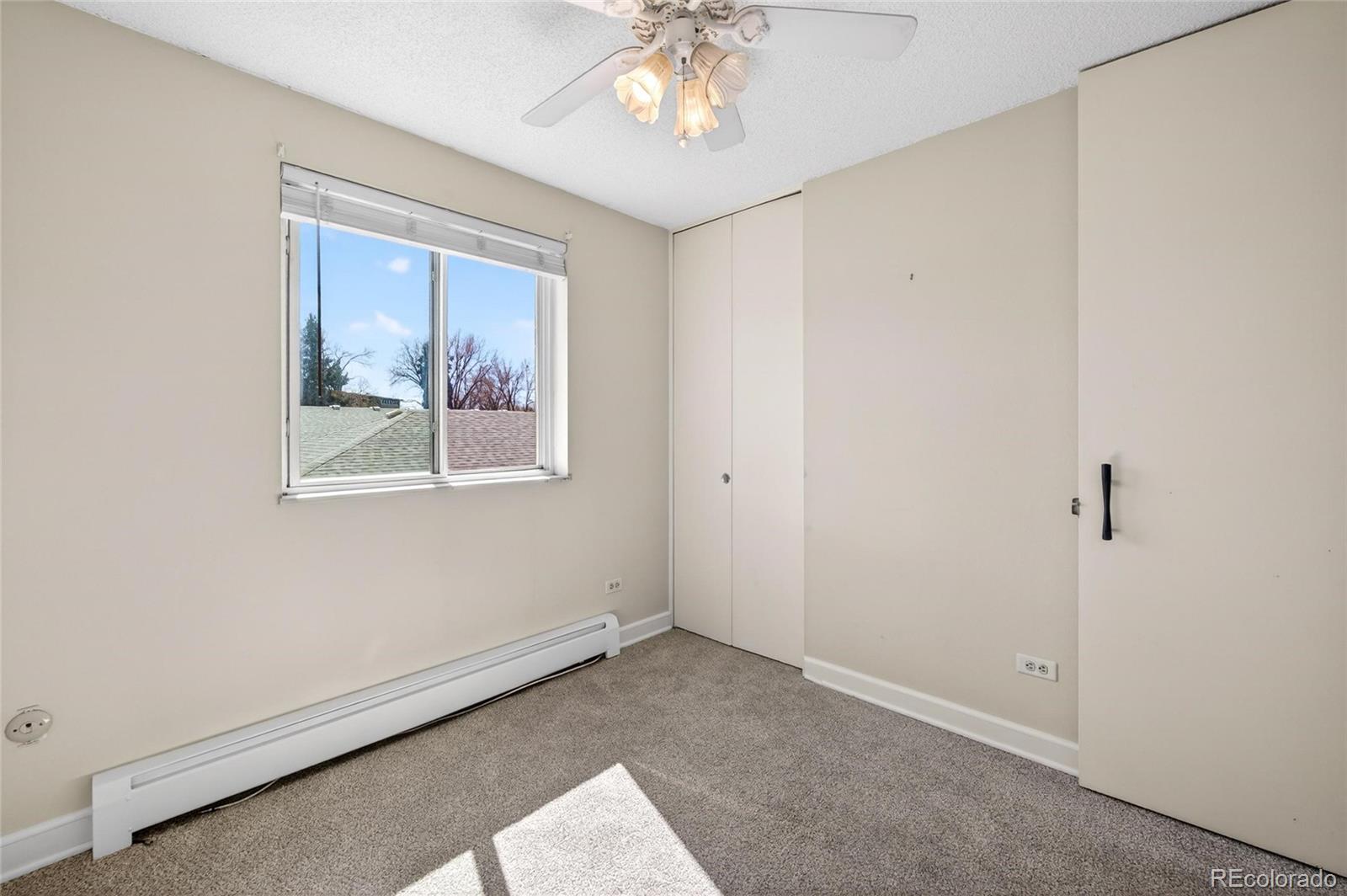720 South Clinton Street, Unit B1 Denver, CO 80247 - Photo 16 of 19 an empty room with windows and chandelier fan