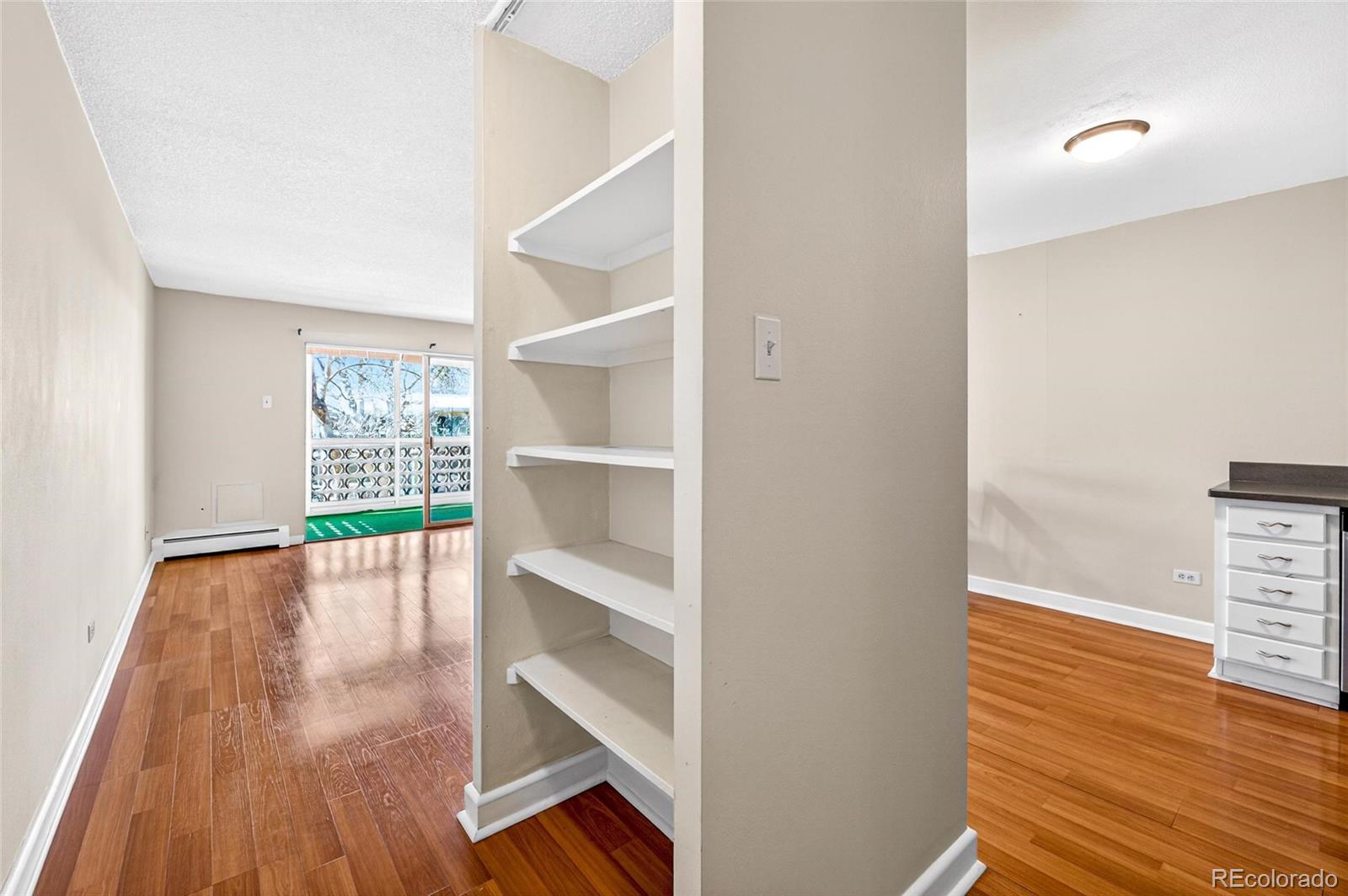 720 South Clinton Street, Unit B1 Denver, CO 80247 - Photo 3 of 19 a view of an empty room with wooden floor and a window