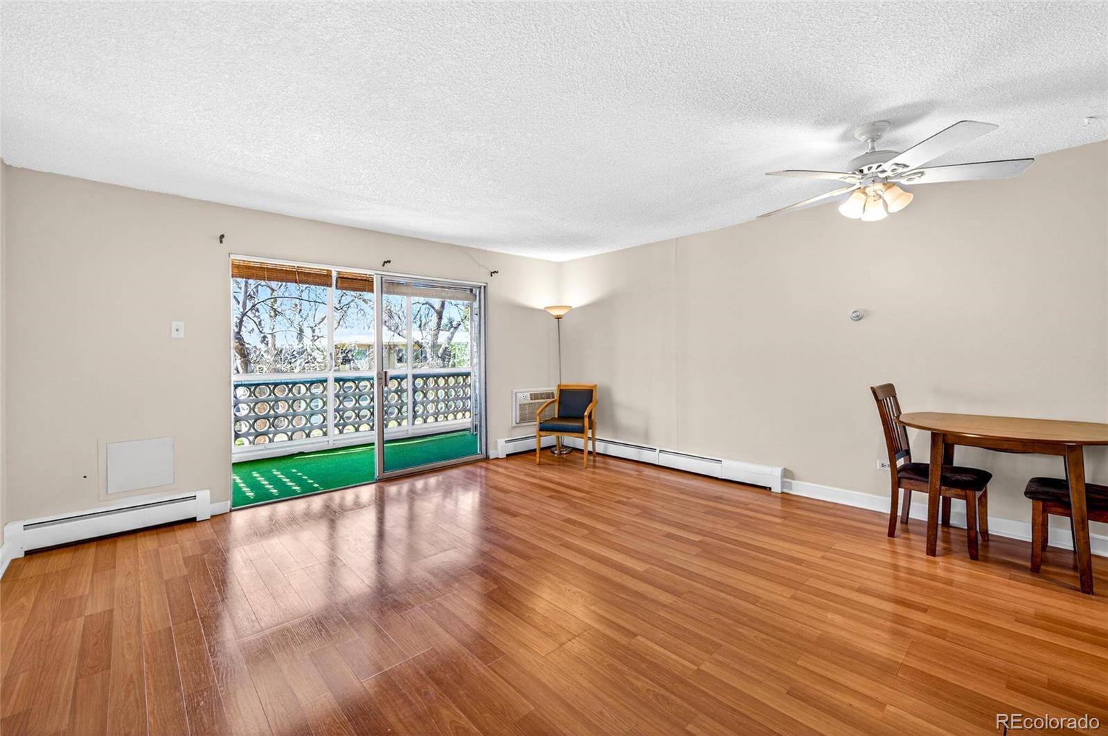 720 South Clinton Street, Unit B1 Denver, CO 80247 - Photo 7 of 19 a view of a livingroom with wooden floor a ceiling fan and windows