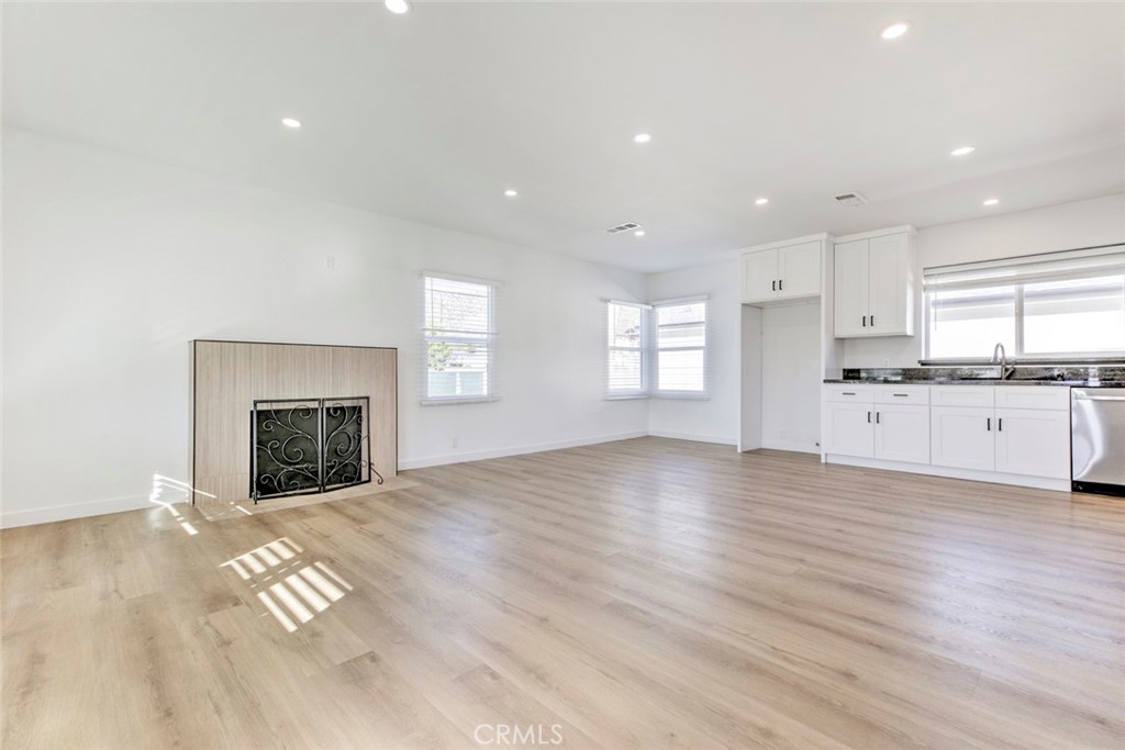 2238 North N Keystone Burbank, CA 91504 - Photo 4 of 21 a view of a kitchen and empty room with wooden floor fireplace and windows