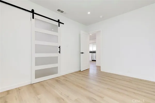 a view of empty room with wooden floor
