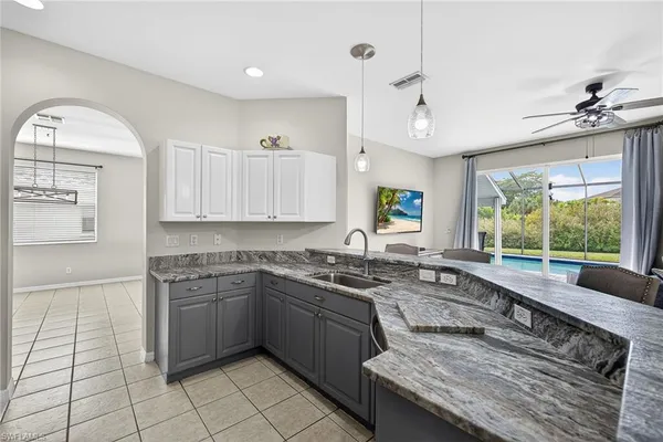 a kitchen with granite countertop white cabinets and stainless steel appliances