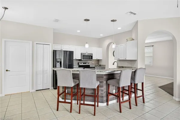 a living room with furniture kitchen view and a window