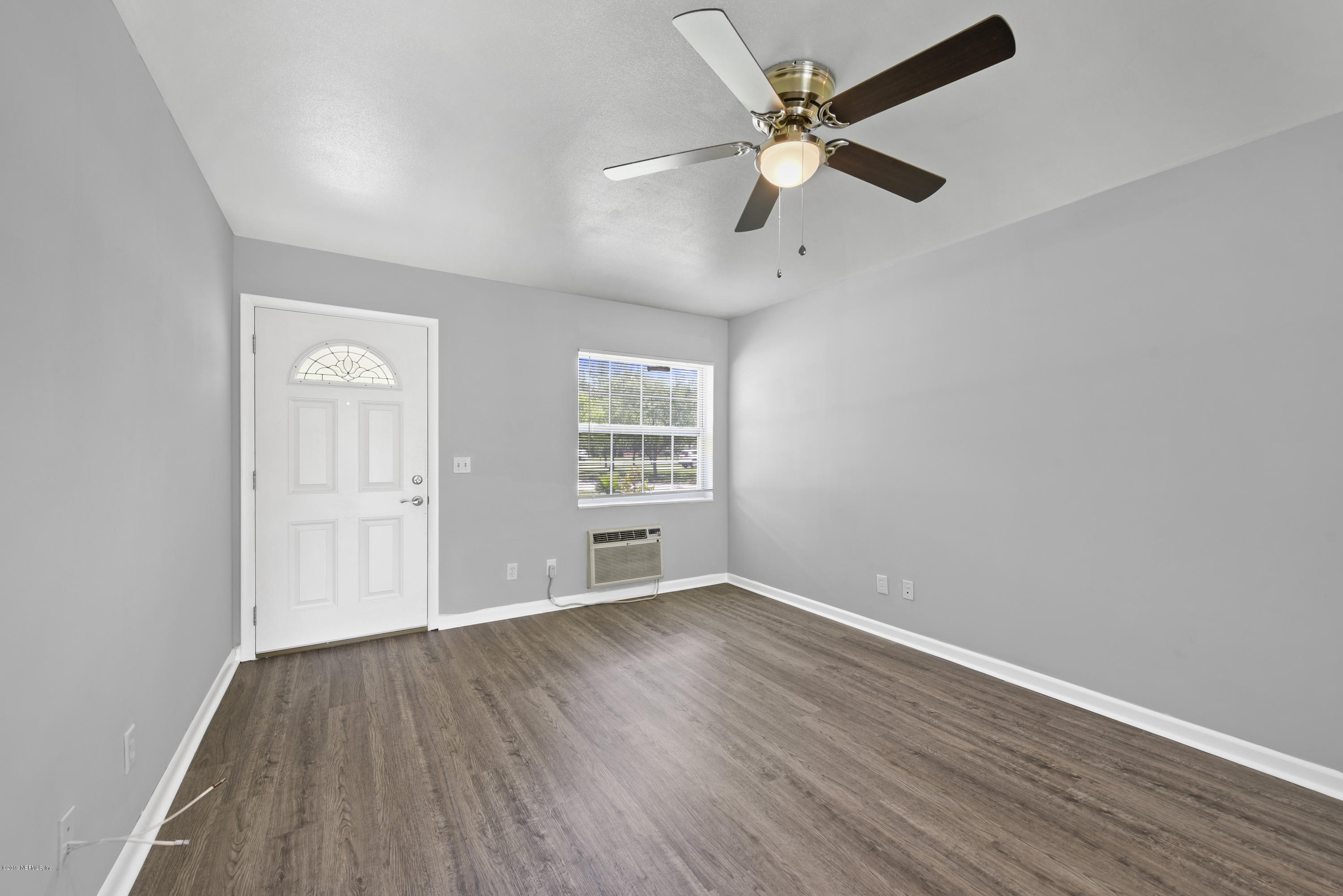 7384 Ridgeway Road North Jacksonville, FL 32244 - Photo 6 of 29 an empty room with wooden floor ceiling fan and windows