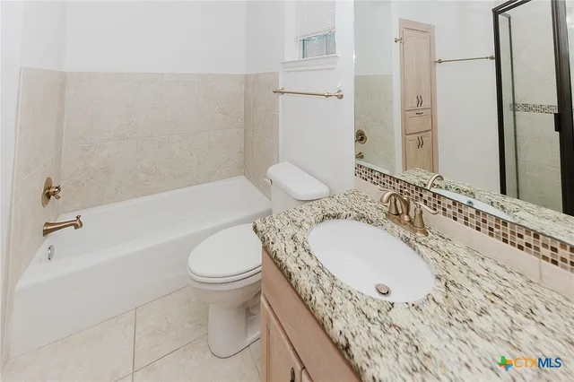 a bathroom with a granite countertop shower mirror and a sink