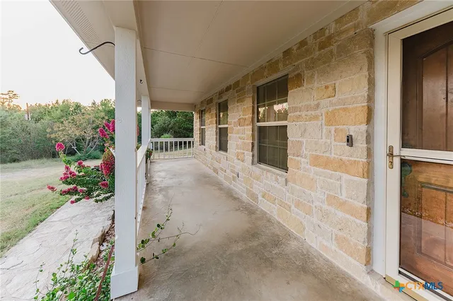 a view of a porch with a door and wooden floor