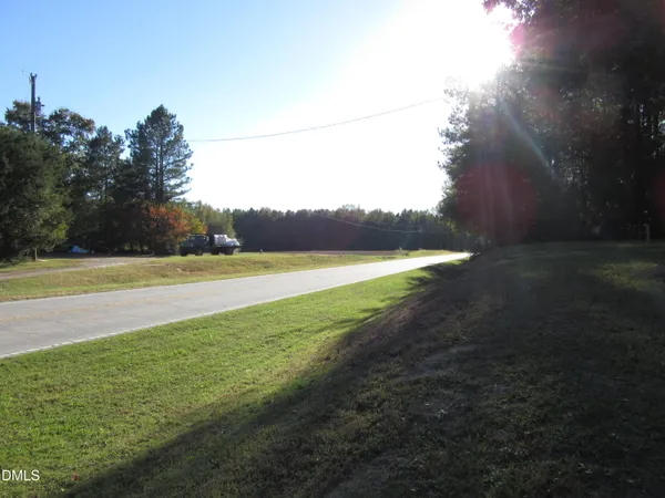 a view of a field of grass and trees