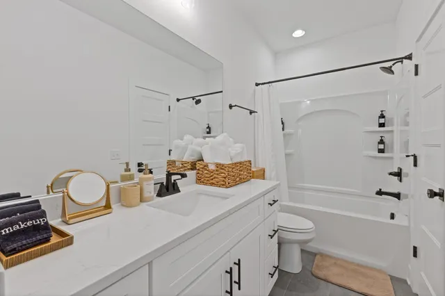 a bathroom with a granite countertop sink a toilet and shower