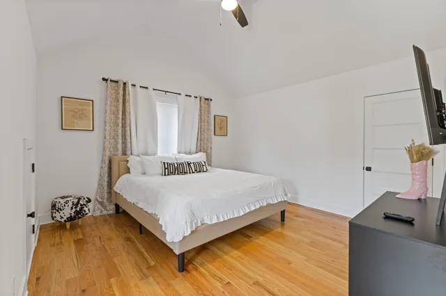 a bedroom with a bed and wooden floor