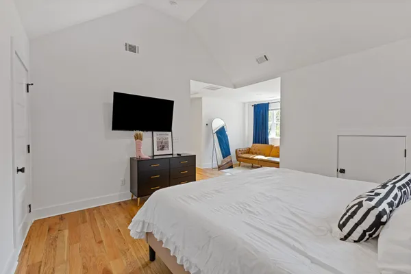 a bedroom with a bed and a flat tv screen on wall