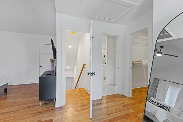 a view of a hallway with wooden floor and staircase