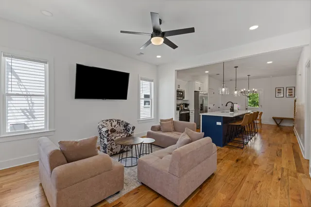 a living room with furniture kitchen view and a flat screen tv