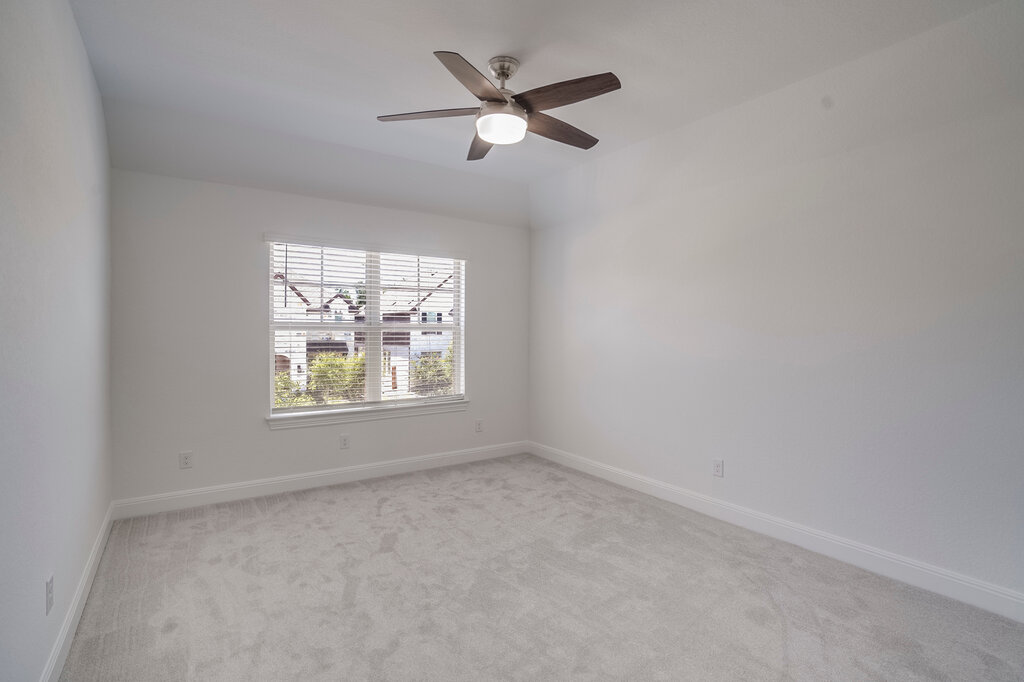 2920 Hadley Way Leander, TX 78641 - Photo 13 of 20 A well-lit bedroom features plush carpeting and a modern ceiling fan for ultimate comfort.
