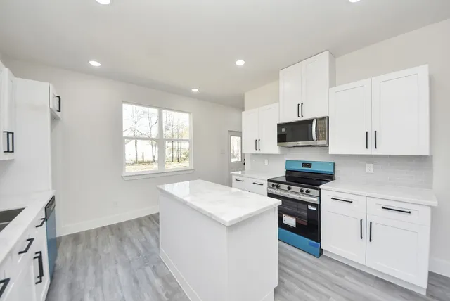 a kitchen with a stove a sink and a microwave