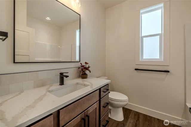 a bathroom with a sink a toilet and mirror