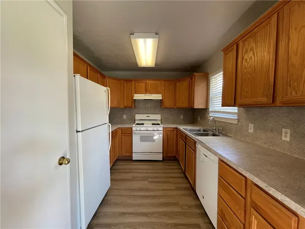 a kitchen with granite countertop a sink a counter top space stainless steel appliances and cabinets