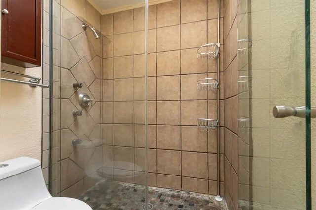 a view of a kitchen with kitchen island a sink stainless steel appliances and cabinets