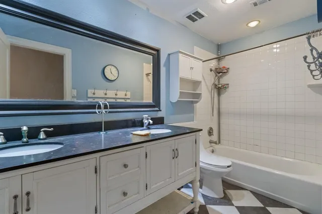 a bedroom with a large bed and paintings on the wall