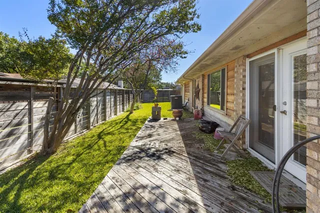 a view of a house with a yard and large trees