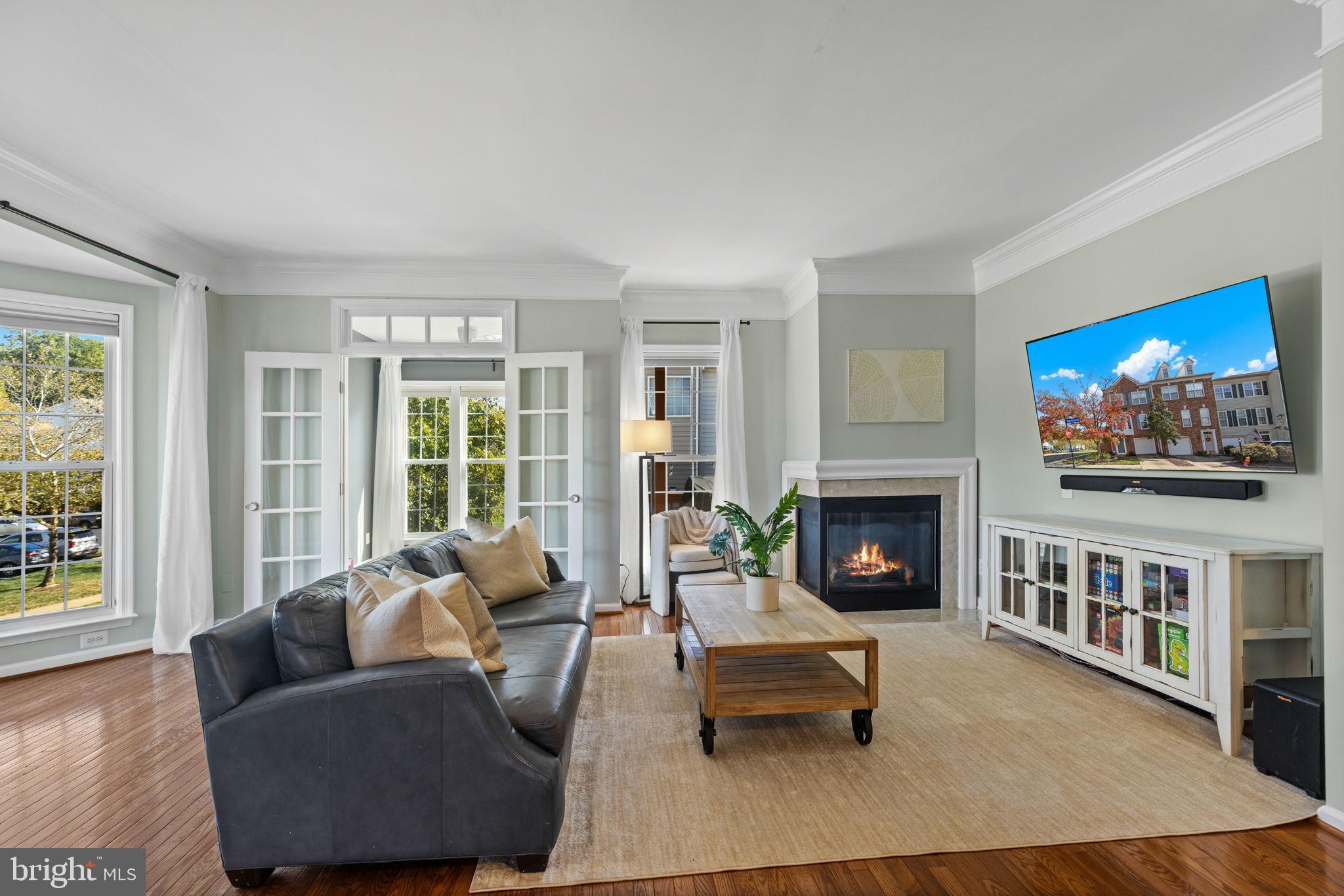 6311 Burgundy Leaf Lane Alexandria, VA 22312 - Photo 2 of 33 a living room with furniture a fireplace and a flat screen tv