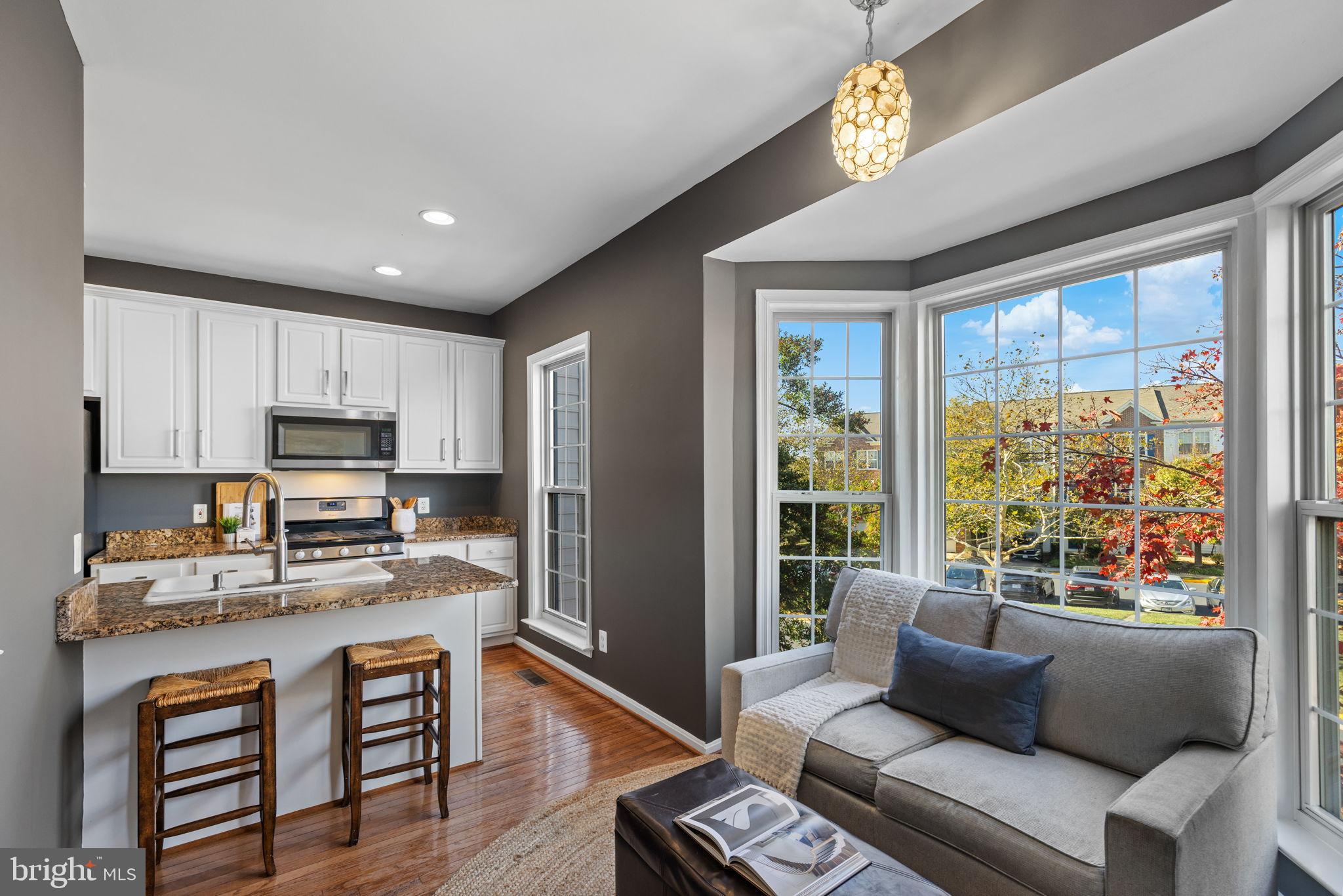 6311 Burgundy Leaf Lane Alexandria, VA 22312 - Photo 7 of 33 a living room with stainless steel appliances granite countertop furniture a rug a stove and a window