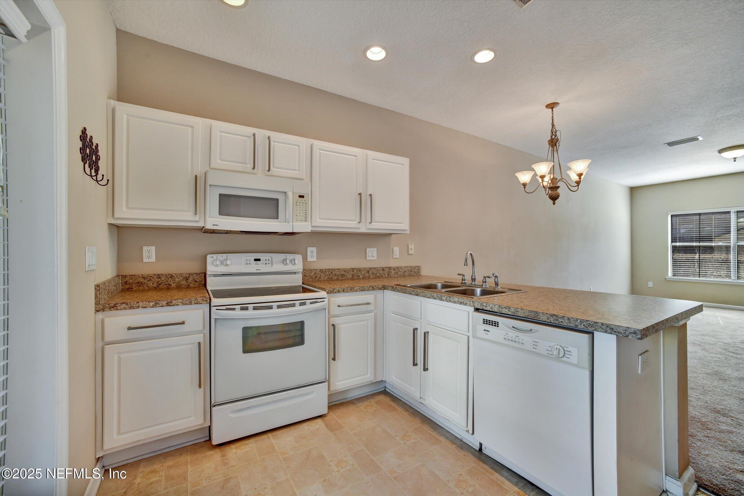 480 Cabernet Place St. Augustine, FL 32084 - Photo 11 of 37 a kitchen with a stove sink and cabinets