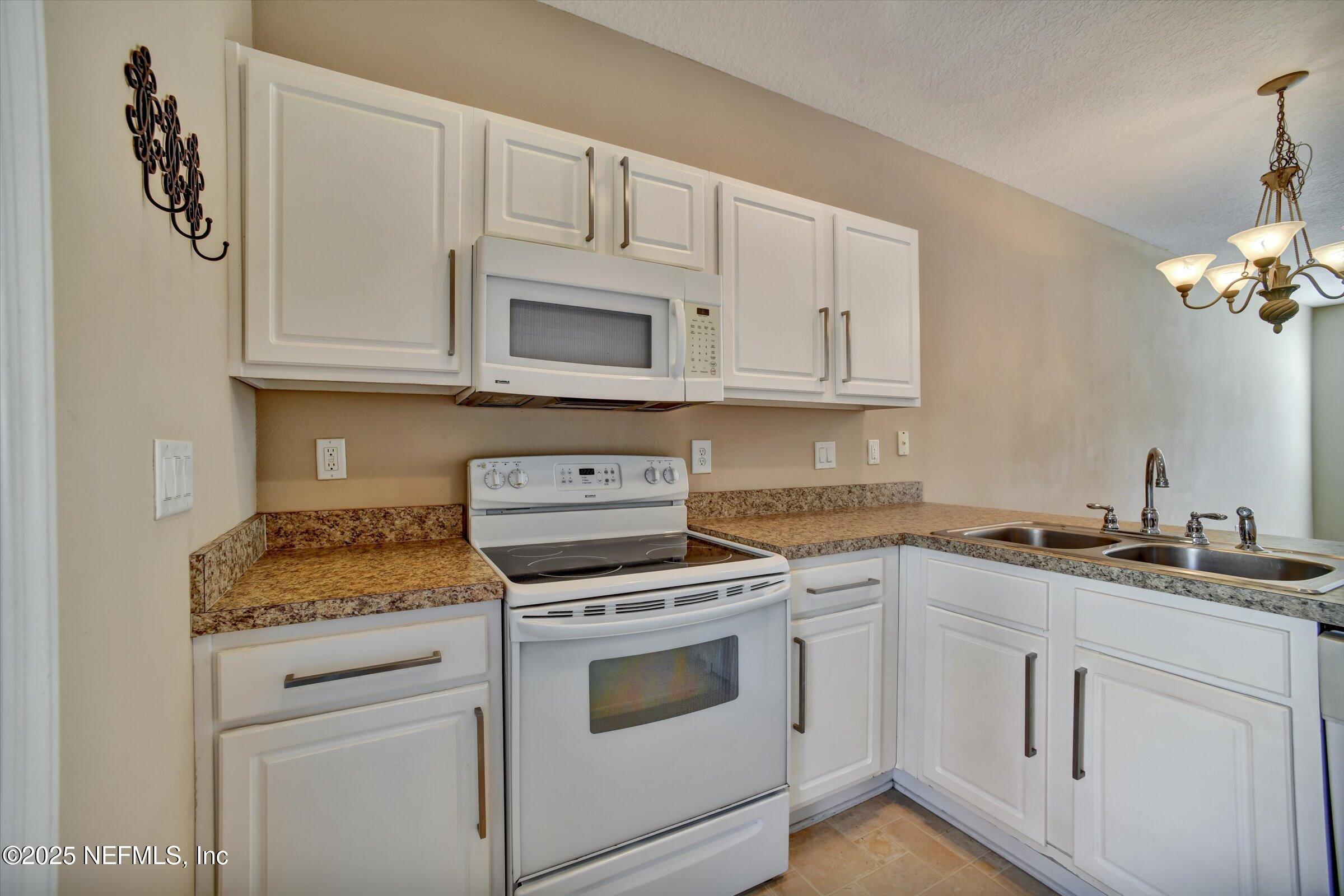 480 Cabernet Place St. Augustine, FL 32084 - Photo 12 of 37 a kitchen with granite countertop white cabinets and white appliances