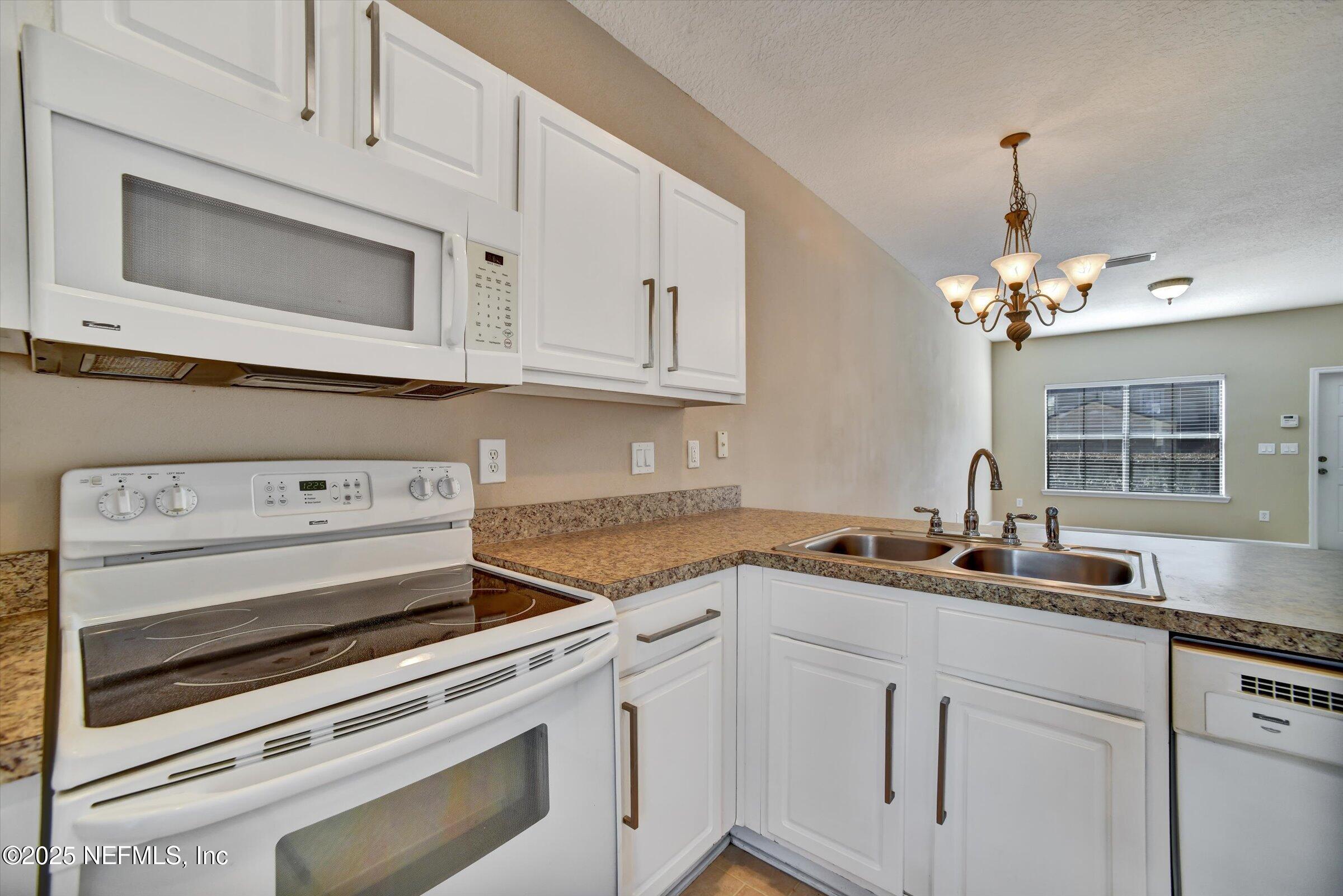 480 Cabernet Place St. Augustine, FL 32084 - Photo 15 of 37 a kitchen with stainless steel appliances granite countertop white cabinets and a stove top oven