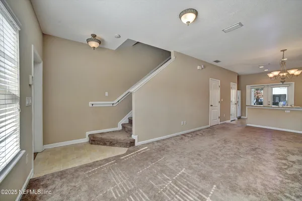en empty room with windows and ceiling fan