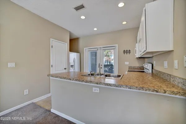 a kitchen with granite countertop white cabinets and white appliances