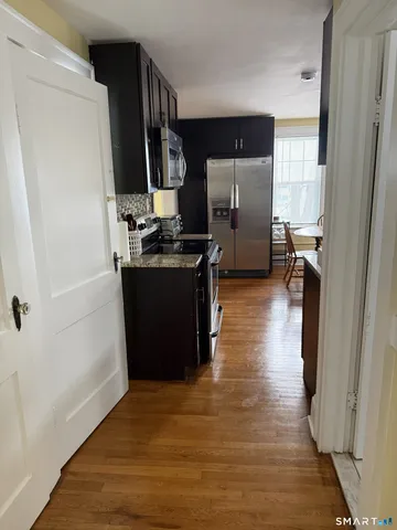 a kitchen with stainless steel appliances granite countertop a refrigerator and a sink