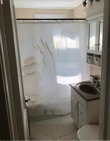 a bathroom with a granite countertop sink toilet and shower