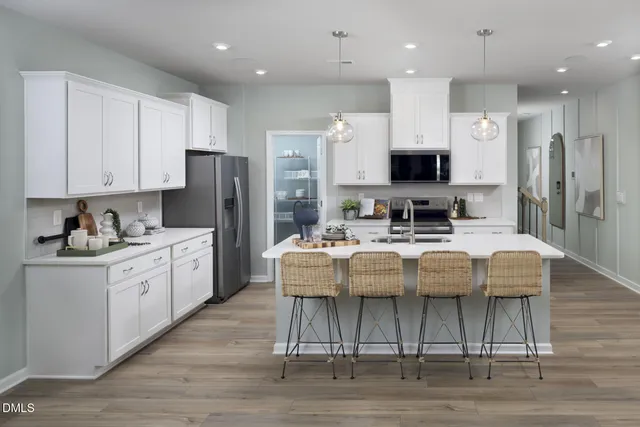 a kitchen with stainless steel appliances granite countertop a stove top oven a refrigerator a sink and a stove