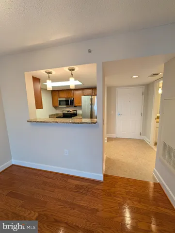 a view of empty room with wooden floor