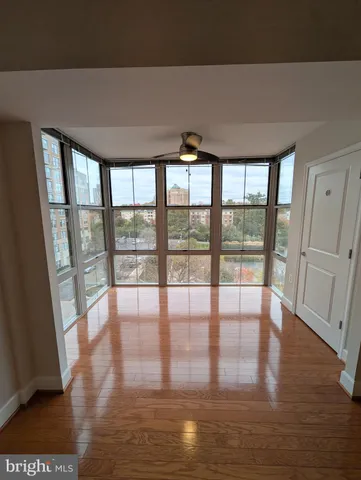 a view of empty room with wooden floor and floor to ceiling window