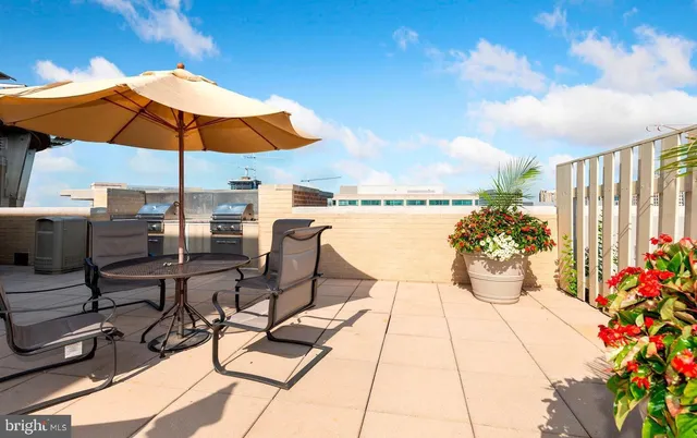 a view of a patio with table and chairs under an umbrella
