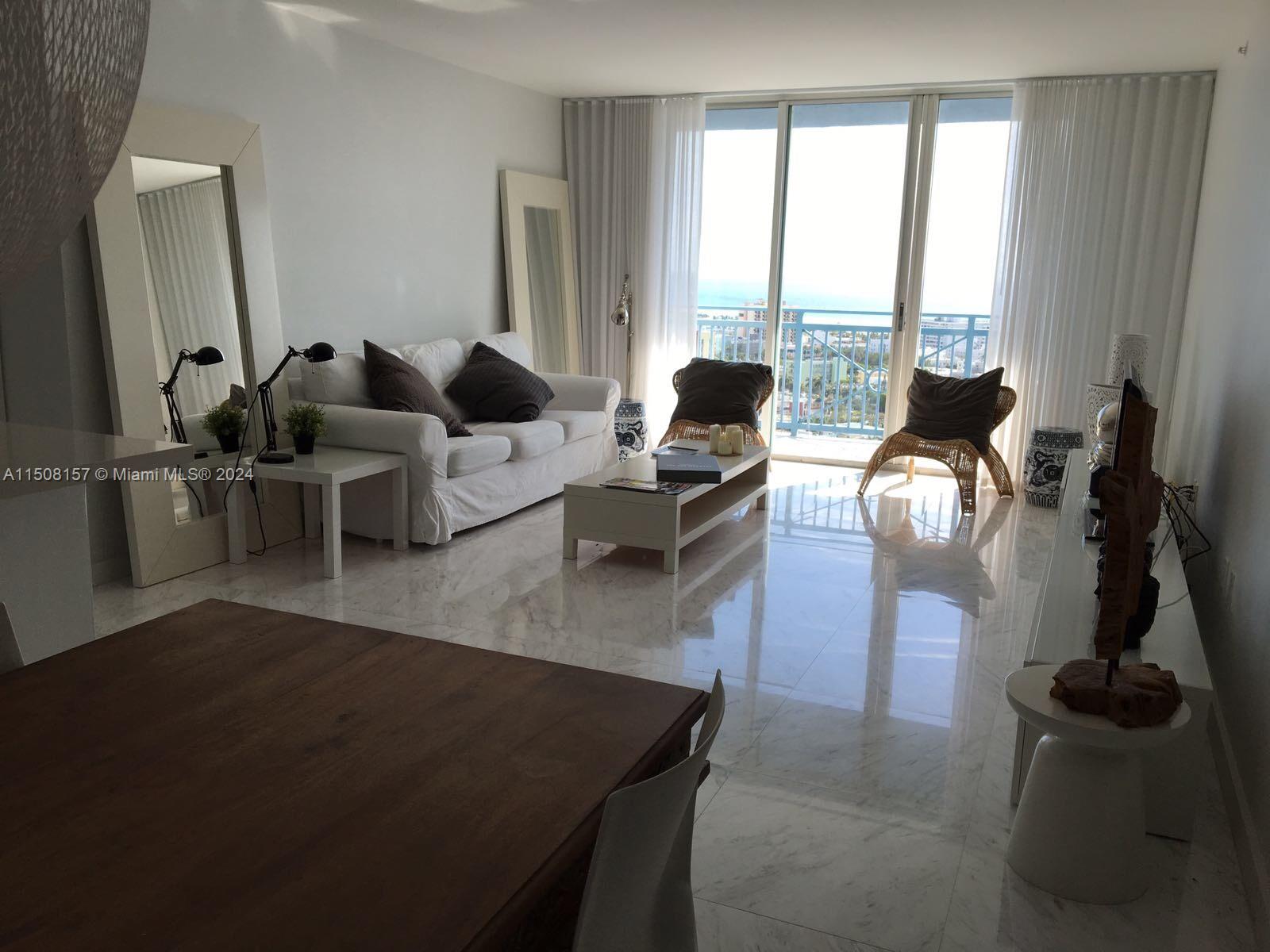 90 Alton Road, Unit 2503 Miami Beach, FL 33139 - Photo 5 of 23 a living room with furniture and a window