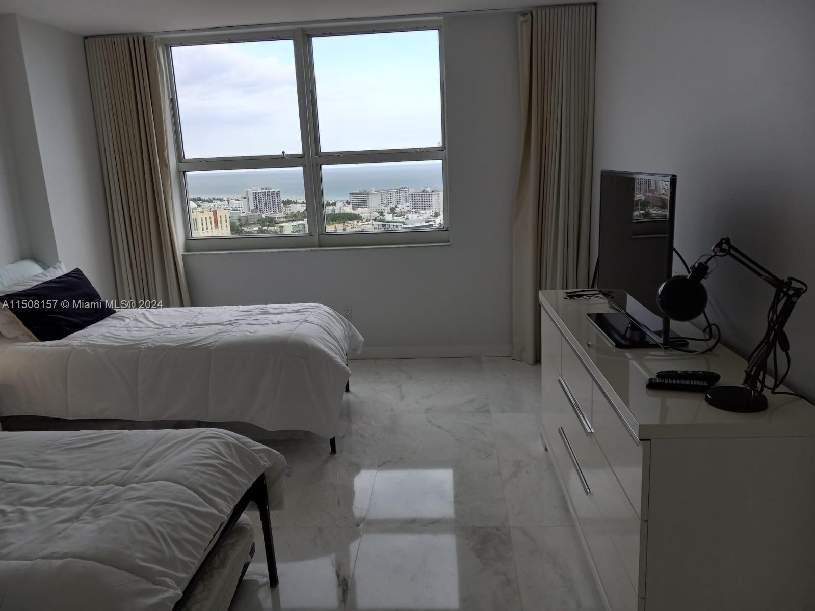 90 Alton Road, Unit 2503 Miami Beach, FL 33139 - Photo 9 of 23 a bedroom with a bed and a window