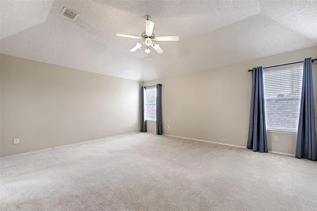 a view of an empty room with a chandelier fan