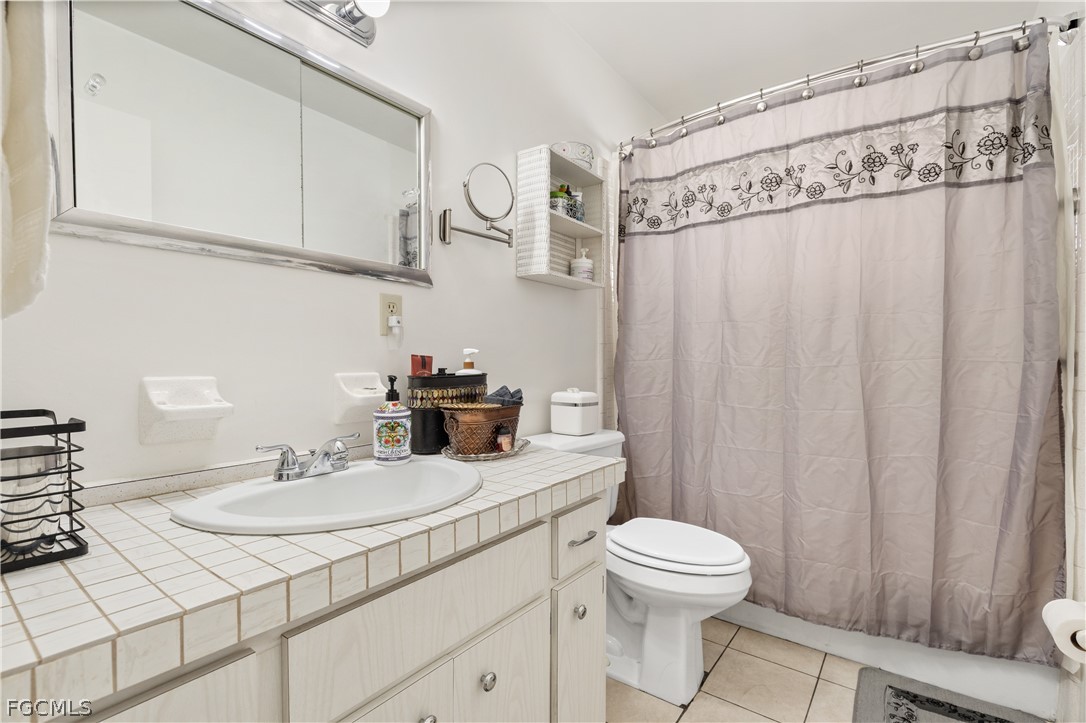337 Richland Road Lehigh Acres, FL 33936 - Photo 14 of 31 a bathroom with a sink a toilet and shower curtain