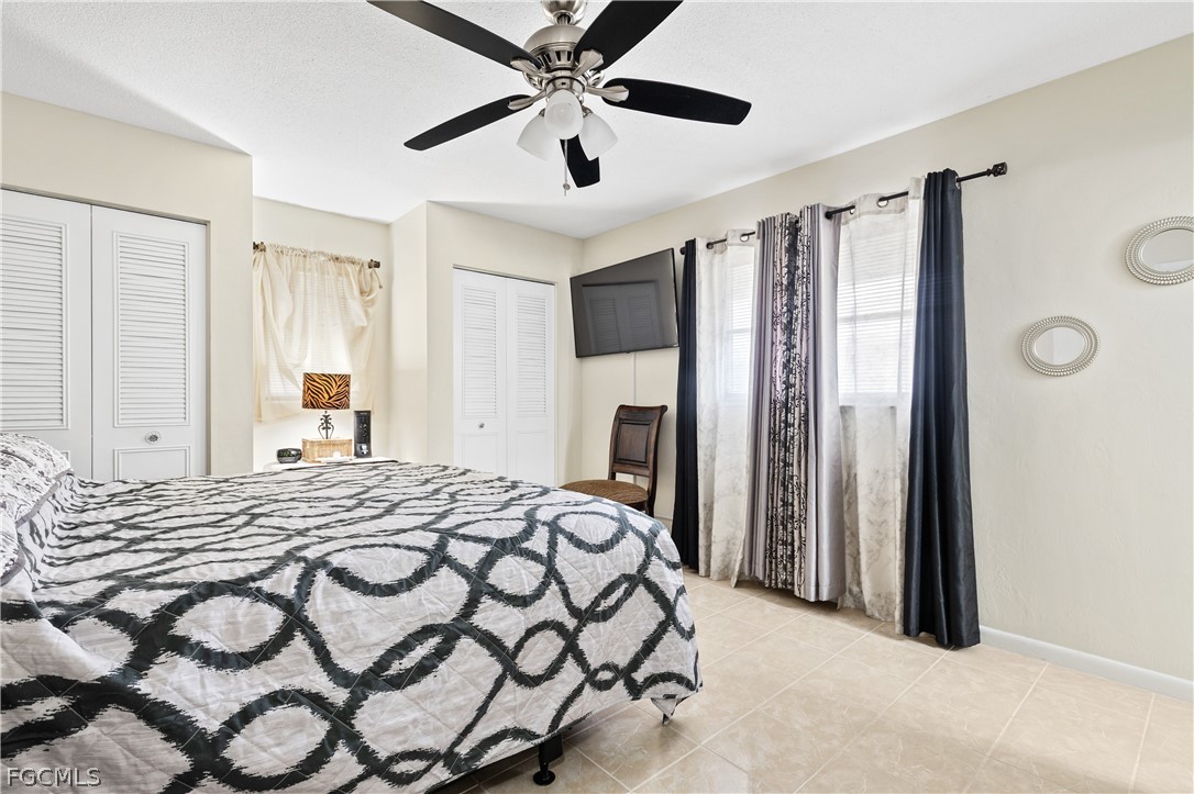 337 Richland Road Lehigh Acres, FL 33936 - Photo 15 of 31 a bedroom with a large bed and a chandelier