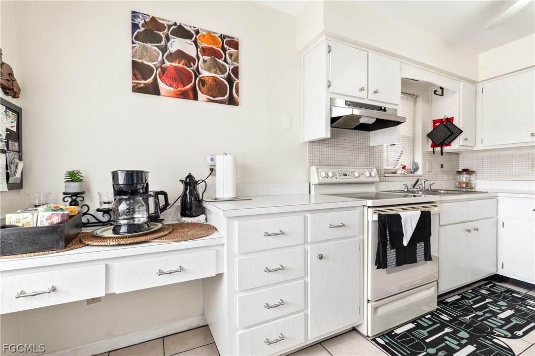337 Richland Road Lehigh Acres, FL 33936 - Photo 3 of 31 a kitchen with white cabinets and white appliances