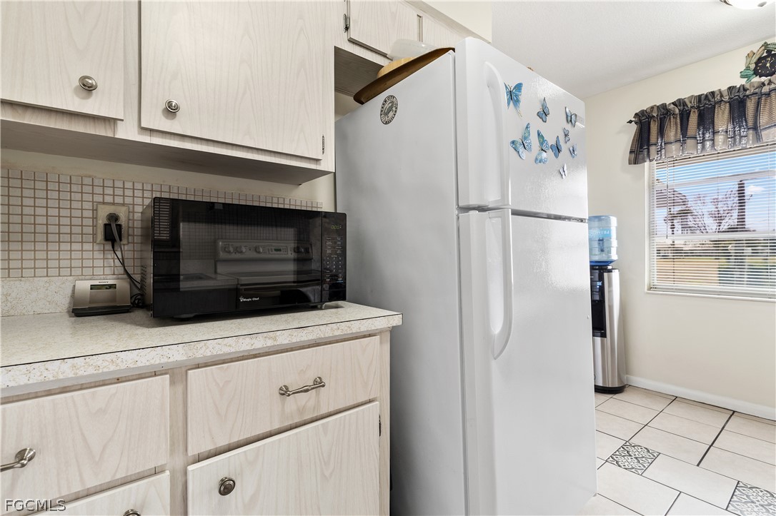337 Richland Road Lehigh Acres, FL 33936 - Photo 5 of 31 a kitchen with stainless steel appliances white cabinets and a refrigerator