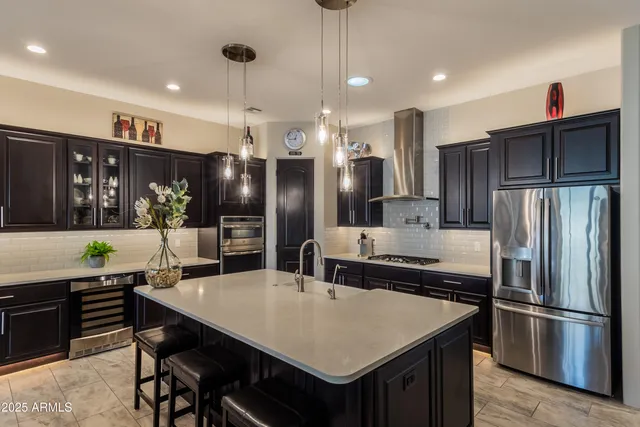 a kitchen with stainless steel appliances granite countertop a refrigerator a sink and a stove