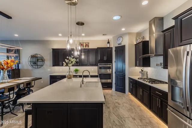 a kitchen with stainless steel appliances granite countertop a sink refrigerator and cabinets
