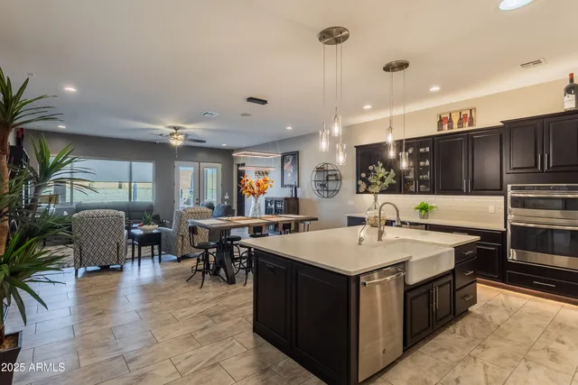 a large kitchen with kitchen island a sink table and chairs