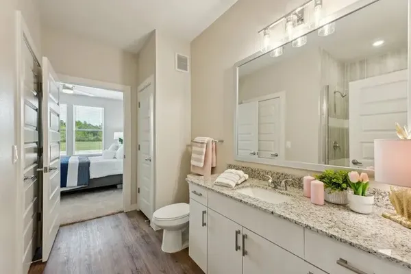 a spacious bathroom with a granite countertop sink mirror and a toilet