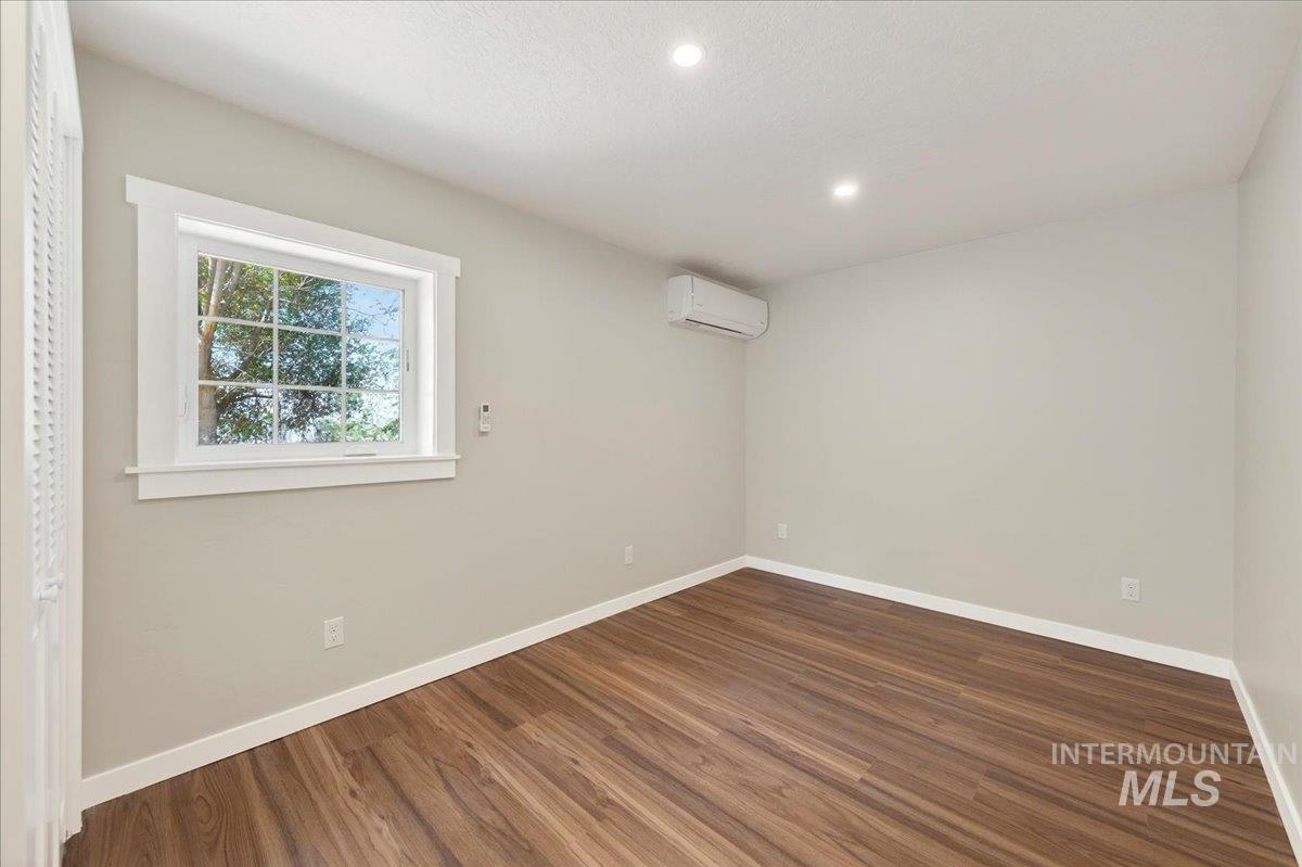 109 Parma Road Parma, ID 83660 - Photo 14 of 31 Room featuring luxury plank flooring, white baseboards, and a window with white trim